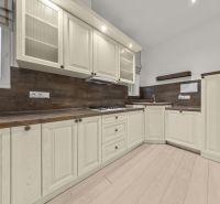  EXKLUZÍVNY, VEĽKOMETRÁŽNY 3i byt ( 130 m2 ), REKONŠTRUKCIA, CENTRUM - Kuchyňa v 3-izbovom byte s bielymi skrinkami a podlahou s dreveným dekorom.