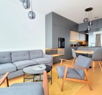 ŠTÝLOVÝ 2i byt, PARKING, KLÍMA, PARKING, Čulenova ulica, SKY PARK - Obývacia izba v 2-izbovom byte s pohovkou, kreslami a kuchyňou, podlaha s dreveným dekorom.
