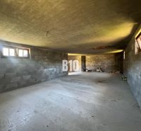Rozostavaná chata, 845m2 pozemok, platné stavebné povolenie - V chate je priestranná miestnosť s nerovným betónovým stropom a malými oknami.