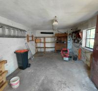 Rodinný dom Martin – Podháj, 5 izieb a pozemok 621 m² - Garáž v rodinnom dome s nástrojmi, paletami a rebríkom. Okná prepúšťajú denné svetlo.