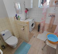 Rodinný dom Martin – Podháj, 5 izieb a pozemok 621 m² - Kúpeľňa v rodinnom dome s práčkou, sprchovým kútom a toaletou, podlaha s dreveným dekorom.