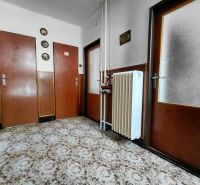 Rodinný dom Martin – Podháj, 5 izieb a pozemok 621 m² - Chodba v rodinnom dome s kobercom, drevenými dverami a radiátorom na stene.