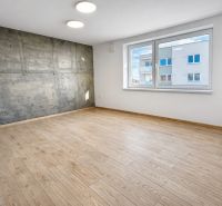 3-izb byt 88,3m2 v štandarde vrátane kuchyne len 15 minút od BA - Prázdna izba s betonovou stenou a podlahou s dreveným dekorom v 3-izbovom byte.