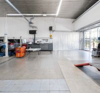MODERNÝ, ZABEHNUTÝ, KOMPLETNE ZARIADENÝ AUTOSERVIS, LOZORNO - Výrobné priestory s autami a závesmi na dlažbe, zariadené servisným vybavením.