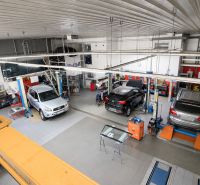 MODERNÝ, ZABEHNUTÝ, KOMPLETNE ZARIADENÝ AUTOSERVIS, LOZORNO - Autodielňa s automobilmi v servisných priestoroch s profesionálnym vybavením a nástrojmi.