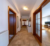 Priestranný 5-izbový rodinný dom (190 m²) s krásne upraveným 13a pozem - Chodba s dlažbovou podlahou vedúca do obývačky v rodinnom dome, drevené dvere.