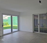 Okr. Senec - Tureň - NA PREDAJ nízkoenergetická novostavba - 4 izbový  - Interiér rodinného domu s veľkými oknami, dlažbou a výhľadom do záhrady.