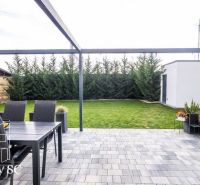NOVÁ CENA - SENEC SLNEČNÉ JAZERÁ JUH – NA PREDAJ – novostavba rekreačn - Terasa rodinného domu na Slnečných jazerách juh v Senci s trávnikom a záhradným sedením.