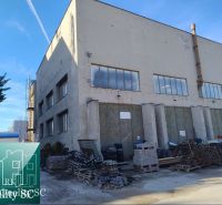 BRATISLAVA III. - RAČA - NA PREDAJ - priemyselný objekt s polyfunkčnou - Priemyselná budova na Staviteľskej ulici v Bratislave III obklopená stavebným materiálom.
