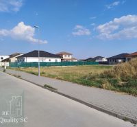 SENEC - NA PREDAJ exkluzívny stavebný pozemok pre rodinné domy - JUŽNÁ - Pozemky na bývanie v Senci obklopené domami a zeleňou pod modrou oblohou.