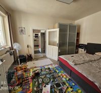 Okres Trnava- obec Pavlice – nehnuteľnosť s potenciálom - 4 izb. RD v  - Spálňa v rodinnom dome s gaučom, hračkami na koberci a veľkou skriňou.