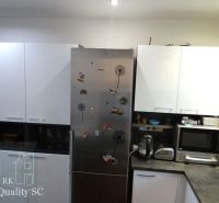REZERVOVANÉ - SENEC - EXKLUZÍVNE NA PREDAJ - kompletne zariadený a kli - Kuchyňa v 3-izbovom byte s bielymi skrinkami a spotrebičmi, zdobené magnetkami.