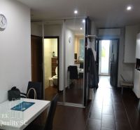 REZERVOVANÉ - SENEC - EXKLUZÍVNE NA PREDAJ - kompletne zariadený a kli - Interiér 3-izbového bytu s hnedou podlahou a jedálenským stolom.