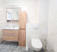 VÝRAZNÁ ZĽAVA novostavba s viacerými bytovými jednotkami - Kúpeľňa v rodinnom dome, Trnava, obsahuje moderné drevené skrinky, zrkadlo, vkusné obklady.