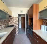 Ex. Moderný 4 iz byt po komplet. rekonštrukcii s lodžiou v Piešťanoch - Kuchyňa v 4-izbovom byte so vzorovaným obkladom a podlahou s dreveným dekorom.