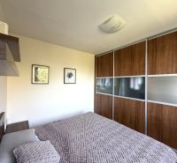 Ex. Moderný 4 iz byt po komplet. rekonštrukcii s lodžiou v Piešťanoch - Spálňa v 4-izbovom byte s priestrannou skriňou a posteľou, podlaha s dreveným dekorom.