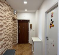 Ex. Moderný 3 iz. byt 90 m2 s garážou a záhradou v Dolnom Trhovišti - Chodba v 3-izbovom byte s dekoratívnou kamennou stenou a dvermi s nálepkami.