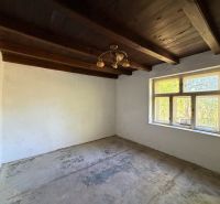 Exkl. 3 izbový rodinný dom v H. Orešanoch ZĽAVA - Miestnosť v rodinnom dome s dreveným stropom a veľkým oknom, podlaha je pripravená na úpravu.