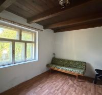 Exkl. 3 izbový rodinný dom v H. Orešanoch ZĽAVA - Izba v rodinnom dome s oknom, sedačkou, podlahou s dreveným dekorom a kočíkom.
