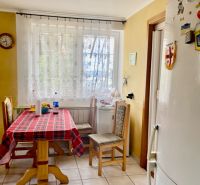 Rekreačný RD pri Oravskej Priehrade na Slanickej Osade - Kuchyňa v rodinnom dome so zariadením, dreveným stolom a chladničkou.