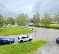 Na predaj 1-izbový byt Bratislavská ul., Dubnica Nad Váhom - Bratislavská ulica v Dubnici nad Váhom s autami a zeleňou pri 1-izbovom byte.