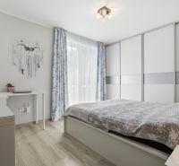 Zariadený 3 izb.byt, 229 m2 záhrada, 2 parkovacie miesta  - Svetlá spálňa s posuvnou skriňou, posteľou a podlahou s dreveným dekorom v 3-izbovom byte.