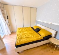 Zariadený 3 izbový byt, 2 park. miesta, 228 m2 záhrada - Spálňa s posteľou, skriňou a podlahou s dreveným dekorom v 3-izbovom byte.