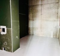 Na PREDAJ | nebytový priestor | Prístavná ulica - Stavenisko obchodných priestorov so zelenou stenou a holými betónovými stenami.