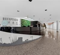 Kancelárie od 20m2 na PRENÁJOM | TOP biznis lokalita - Recepcia v kanceláriách s vertikálnou záhradou, lesklými podlahami a bielymi stenami.