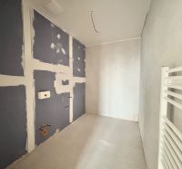 Na PREDAJ | 4izb. veľkometrážny ateliér | Prístavná ulica - Nedokončená kúpeľňa s obkladmi a radiátorom v 4-izbovom byte.