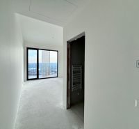Na PREDAJ | 4izb. veľkometrážny ateliér | Prístavná ulica - Chodba v 4-izbovom byte s veľkým oknom, vidieť nedokončenú podlahu a výhľad.