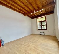 DUNASJKÁ STREDA – OBCHODNÝ/ADMINISTRATÍVNY PRIESTOR PRIAMO V CENTRE ME - Obchodné priestory s podlahou s dreveným dekorom a veľkým oknom, hasičský prístroj v rohu.