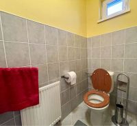 VKUSNÝ 4-IZBOVÝ RODINNÝ DOM S GARÁŽOU NA PREDAJ V OBCI TOPOĽNÍKY - Kúpeľňa v rodinnom dome s toaletou, rebríkovým radiátorom a obkladom v žlto-sivej farbe.