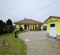 VKUSNÝ 4-IZBOVÝ RODINNÝ DOM S GARÁŽOU NA PREDAJ V OBCI TOPOĽNÍKY - Rodinný dom v Topoľníkoch so žltou fasádou, dlažbou a udržiavanou záhradou.
