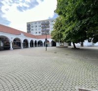Obchodný priestor na prenájom v srdci Dunajskej Stredy - Obchodné priestory s klenbami a stromami na námestí v Dunajskej Strede.
