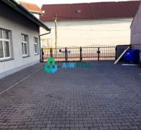 Predádzkový objekt na prenájom v centre mesta - Dvor v obchodných priestoroch Dunajskej Stredy s bránou a smetnými nádobami.