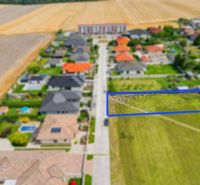 Stavebný pozemok v novej štvrti obce Ohrady – 969 m² - Letecký pohľad na pozemky pre bývanie v Ohradoch lemované domami s dvormi.