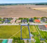 Stavebný pozemok v novej štvrti obce Ohrady – 969 m² - Pozemok v Ohradoch na neuvedenej ulici určený pre bývanie, obklopený domami a poľami.