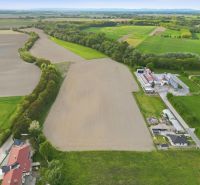 INVESTIČNÝ POZEMOK NA PREDAJ │ VÝNIMOČNÁ PRÍLEŽITOSŤ PRE INVESTOROV - Letecký pohľad na poľnohospodárske pozemky v Dunajskom Klátove, medzi ktorými vedie cesta.