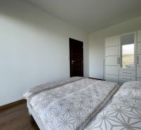 2-IZBOVÝ BYT S VEĽKÝM BALKÓNOM NA PREDAJ - Spálňa s posteľou, skriňou a podlahou s dreveným dekorom v 2-izbovom byte.