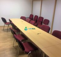 Kancelárie v centre mesta. - Zasadacia miestnosť s dlhou drevenou stolom, červenými stoličkami a podlahou s dreveným dekorom.