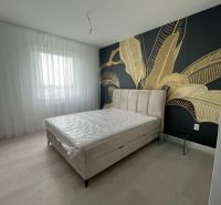 Luxusný byt na prenájom úplne nový kompletne zariadený s garážou. - Spálňa v 3-izbovom byte s dekoratívnou stenou a podlahou s dreveným dekorom.