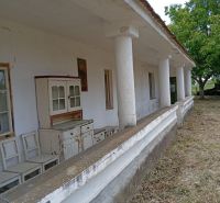 Vidiecky domček na predaj. - Starší rodinný dom v Ňárade s verandou a vintage nábytkom pred domom.