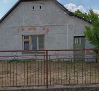 Vidiecky domček na predaj. - Rodinný dom v Ňárade so starou fasádou, plotom a zatvorenými oknami.