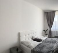 Ůžasný rodinný dom v obci Trstice. - Spálňa v rodinnom dome s bielym nábytkom, šedými závesmi a dekoratívnym zrkadlom.