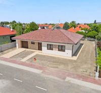 Moderný 4-izbový rodinný dom s garážou  v TOP lokalite pri termálnom k - Rodinný dom v Dunajskej Strede s červenou strechou a záhradou v mestskom prostredí.