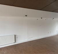 Prenájom nebytového priestoru na podnikateľské účely v CENTRE Dunajske - Interiér budovy s podlahou s dreveným dekorom, bielymi stenami a radiátorom.