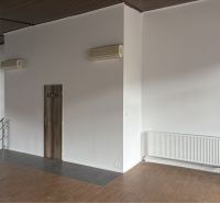 Prenájom nebytového priestoru na podnikateľské účely v CENTRE Dunajske - Podlaha s dreveným dekorom, biele steny, dvere s nápisom 