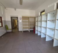 Na prenájom polyfunkčný objekt v DS - Interiér miestnosti s policami, stoličkou a hasiacim prístrojom, v budove.