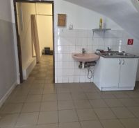 Na prenájom polyfunkčný objekt v DS - Interiér budovy s kuchynskou linkou a umývadlom, na podlahe keramická dlažba.